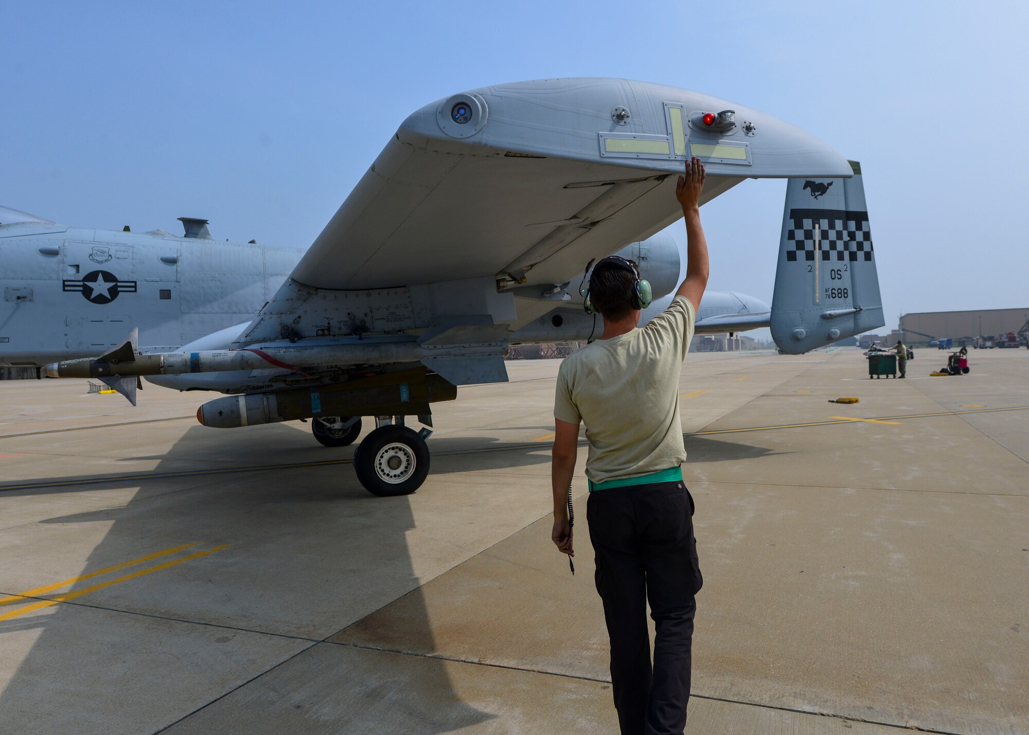 Senior Airman Paul Willett, 51st Aircraft Maintenance Squadron crew chief, gives a farewell tap to an A-10 Thunderbolt II as it departs for a training sortie at Osan Air Base, Republic of Korea, June 9, 2016. Maintenance Airmen are responsible for keeping 51st Fighter Wing aircraft in top condition and ready to fight tonight. (U.S. Air Force photo by Senior Airman Victor J. Caputo/Released)