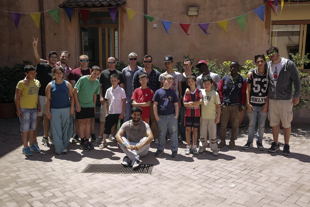 Marines with Special Purpose Marine Air-Ground Task Force Crisis Response-Africa, pose for a photo with children and staff at Marie Ausiliatrice School in Catania, Italy, June 7, 2016.  Marines volunteered their time performing general site maintenance and building an above ground pool in preparation for a summer camp at the orphanage.  (U.S. Marine Corps photo by Cpl. Alexander Mitchell/released)