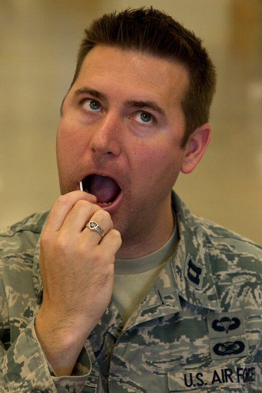 U.S. Air Force Reserve Capt. Casey Staheli, public affairs officer, 913th Airlift Group, swabs skin cells from the inside of his cheek in the Base Exchange at Little Rock Air Force Base, Ark., June 7, 2016. Staheli registered with the C. W. Bill Young Department of Defense Marrow Donor Program during a recruitment drive coordinated by the 19th Security Forces Squadron and Rising 6 organization. (U.S. Air Force photo by Master Sgt. Jeff Walston/Released)  