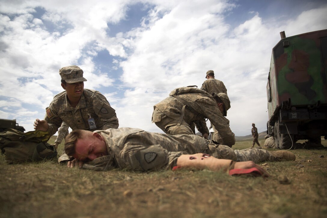 Soldiers provide medical care to a simulated casualty during a practical application exercise in the combat medical care training lane of Khaan Quest 2016 at Five Hills training area near Ulaanbaatar, Mongolia, May 30, 2016. Marine Corps photo by Cpl. Janessa K. Pon