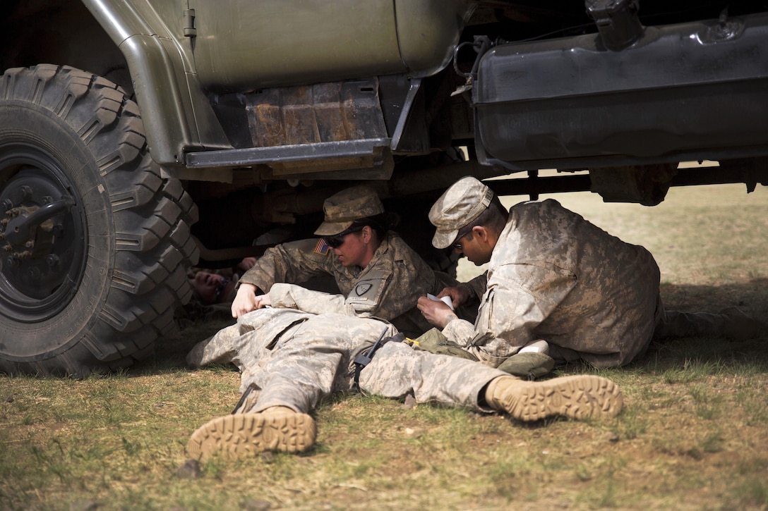 Soldiers provide medical care to a simulated casualty near a vehicle during a practical application exercise in the combat medical care training lane of Khaan Quest 2016 at Five Hills training area near Ulaanbaatar, Mongolia, May 30, 2016. Marine Corps photo by Cpl. Janessa K. Pon