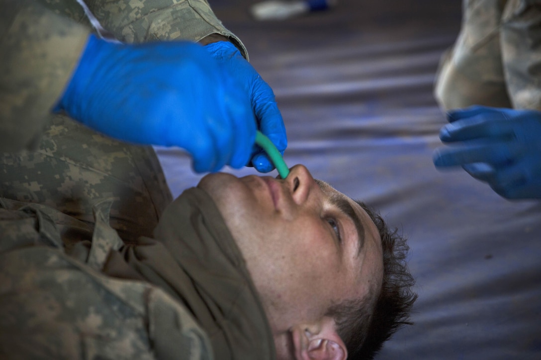 An Army medic, (not shown), inserts a nasopharyngeal airway tube into Army Spc. Caleb Schneck’s nasal passage during a practical application exercise in the combat medical care training lane of Khaan Quest 2016 at Five Hills training area near Ulaanbaatar, Mongolia, May 30, 2016. Marine Corps photo by Cpl. Janessa K. Pon