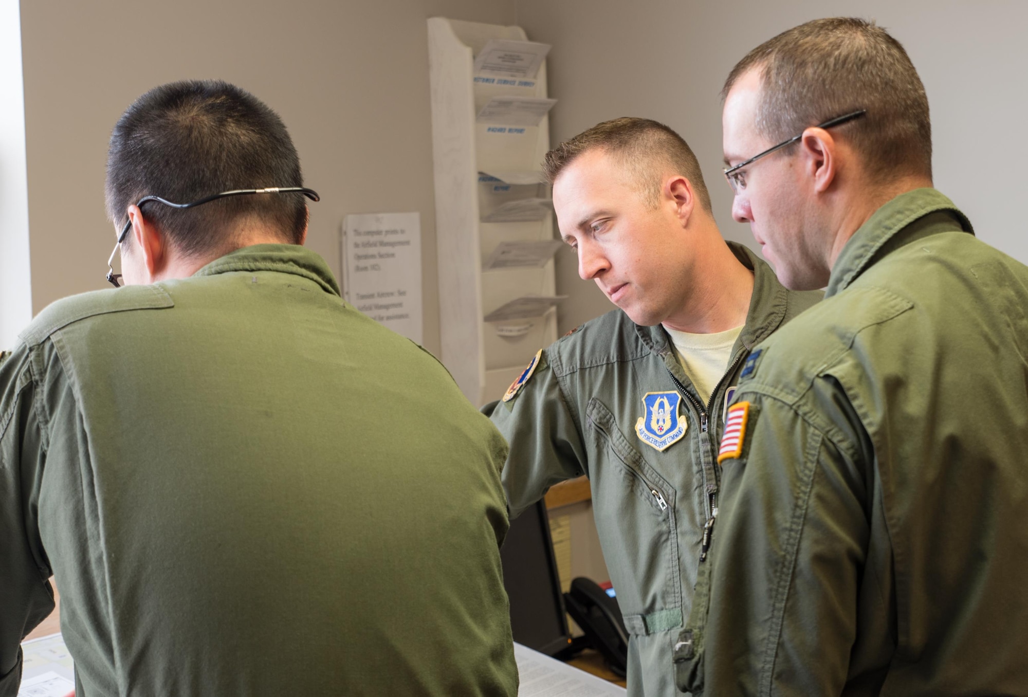 Maj. Ethan Bryant and Capt. Mike McFadden, pilots from the 96th Airlift Squadron, go over their pre-flight plans with Senior Master Sgt. Thomas Kim. (U.S. Air Force photo by Master Sgt. Eric Amidon)