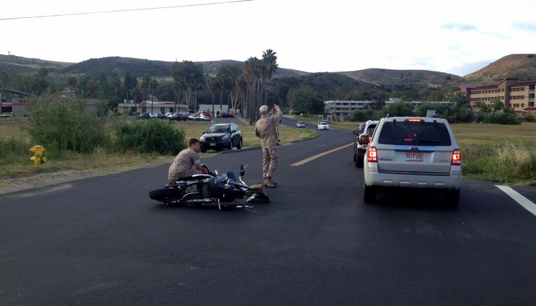 Seaman Max Norum, a corpsman with Headquarters and Support Company, 1st Supply Battalion, treats Sgt. Brandon Jackson for injuries sustained in a motorcycle accident aboard Camp Pendleton, Calif., May 23, 2016. Jackson, an airframes mechanic instructor at the Center for Naval Aviation Technical Training,was on his daily commute to work when he collided with a passenger vehicle. He sustained only minor injuries in the accident. (Courtesy Photo)