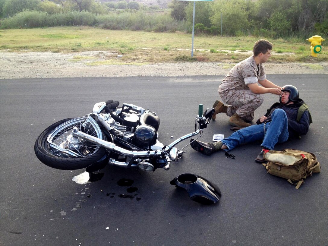 Seaman Max Norum, a corpsman with 1st Supply Battalion, Headquarters and Support Company treats Sgt. Brandon Jackson for injuries sustained in a motorcycle accident aboard Camp Pendleton, Calif., May 23, 2016. Jackson, an airframes mechanic instructor at the Center for Naval Aviation Technical Training, was on his daily commute to work when he collided with a passenger vehicle. He sustained only minor injuries in the accident. (Courtesy Photo)