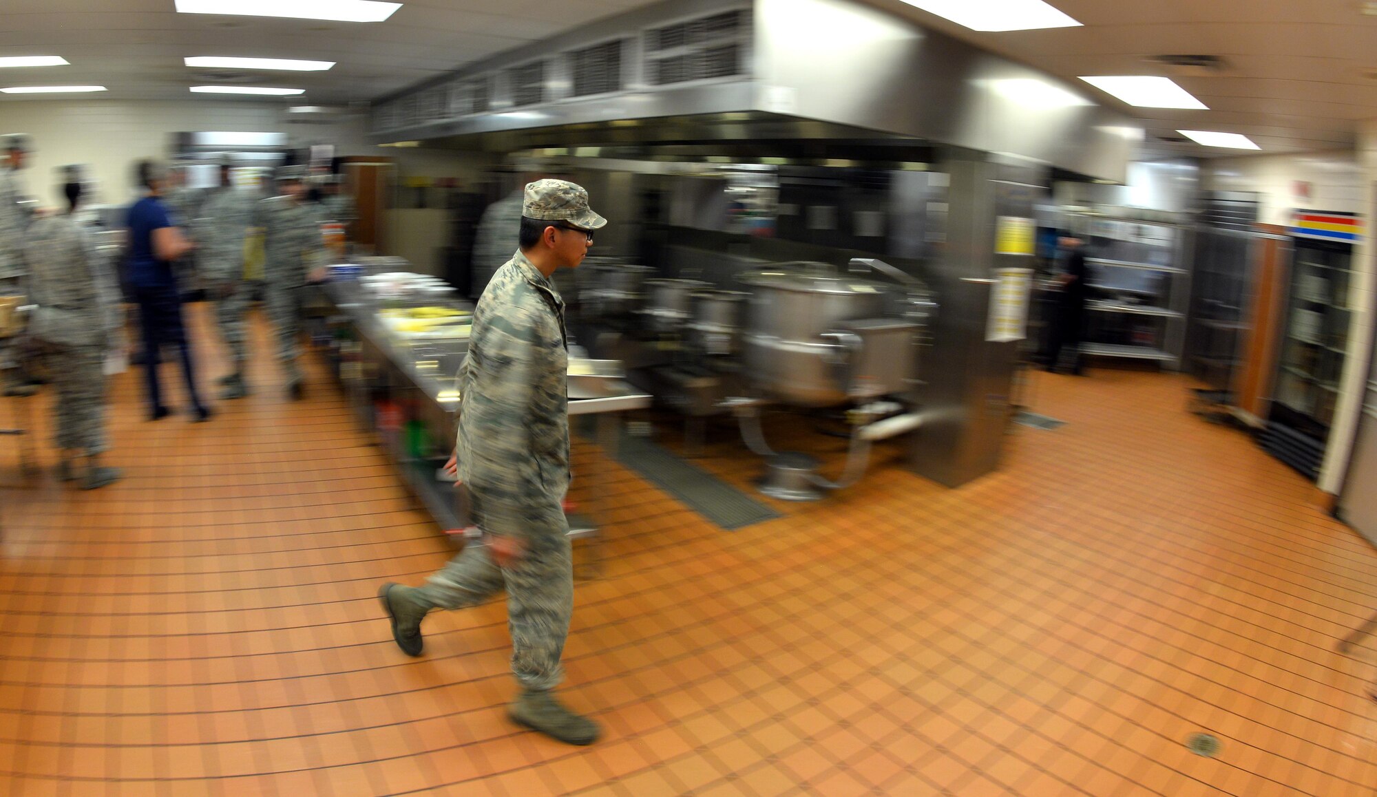 U.S. Air Force Airman 1st Class Jeff Serrano, a food service specialist with the 55th Force Support Squadron, walks through the Ronald L. King Dining Facility kitchen during an Iron Chef Competition held June 2, Offutt Air Force Base, Neb.  Two team of food service specialists had to come up with three seperate dishes each incorporating plantains to be served to a panel of judges.  (U.S. Air Force photo by Josh Plueger/Released)