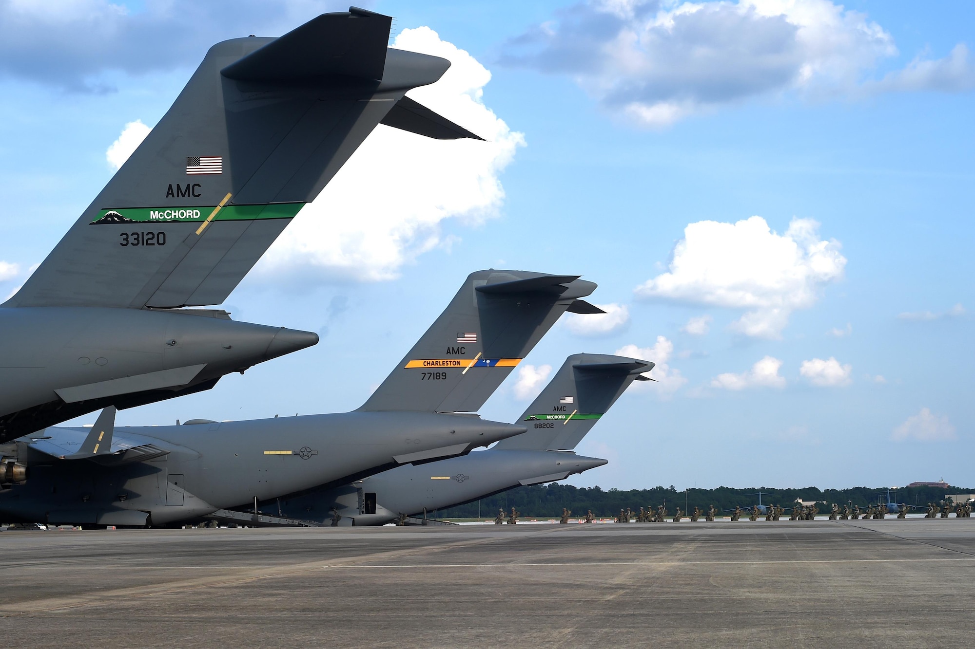 Two 62nd Airlift Wing C-17 Globemaster III aircraft (foreground and background) and one Joint Base Charleston, South Carolina C-17 sit on the Pope Army Air Field flightline, North Carolina, June 4, 2016. The McChord tails were at Pope in support of the upcoming Swift Response exercise. (U.S. Air Force photo/Staff Sgt. Naomi Shipley)