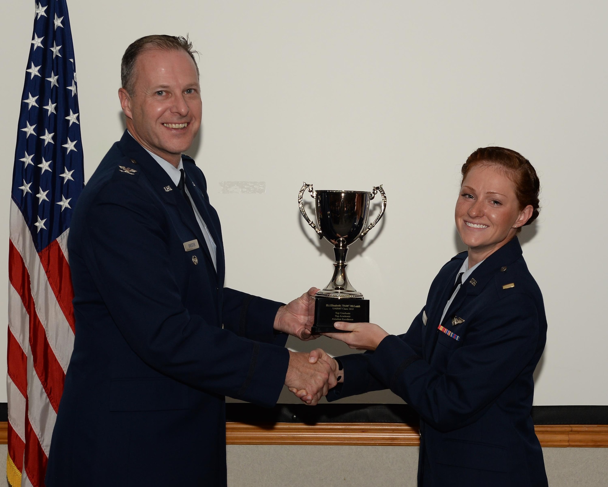 Col. Timothy L. Brester, 461st Air Control Wing vice commander, Robins Air Force Base, Ga., presents 2nd Lt. Elizabeth McLamb, 337th Air Control Squadron air battle manager student, with the Top Graduate award June 8, 2016, at Tyndall Air Force Base, Fla. The Top Graduate award is only given to students who show exemplary performance during their nine-month course, learning what it takes to be air battle managers. The 337th ACS air battle manager students learn command and control mission execution as air battle managers in a variety of weapons systems in support of air expeditionary forces worldwide, and provide command and control support for the F-22 Raptor initial and transition training. (U.S. Air Force photo by Airman 1st Class Cody R. Miller/Released)
