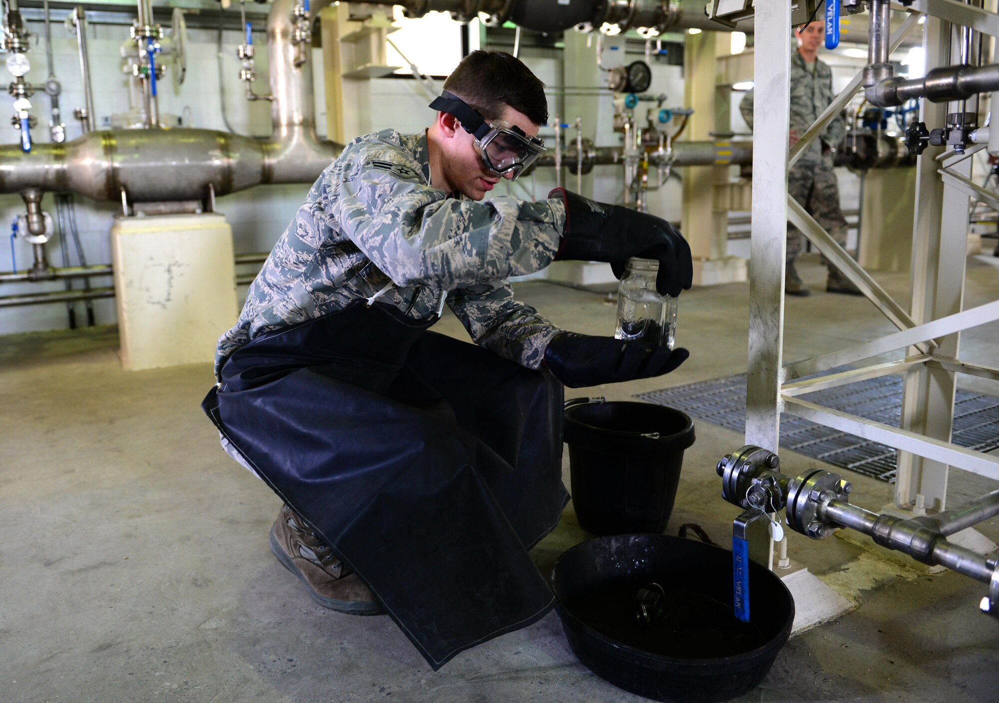 Airman 1st Class Levi Prickett, a 354th Logistics Readiness Squadron fuels facilities operator, drains a fuel sample from the pump house June 7, 2016, at Eielson Air Force Base, Alaska. Prickett checks that no particles or water is found in the fuel to ensure everything runs smoothly during RED FLAG-Alaska 16-2. (U.S. Air Force photo by Airman 1st Class Cassandra Whitman/Released)