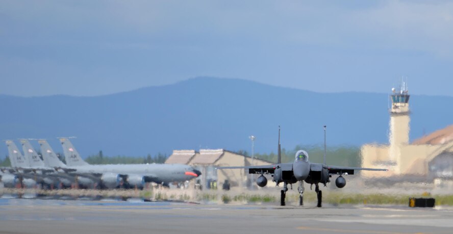 A U.S. Air Force F-15E Strike Eagle all-weather, highly maneuverable, dual-role fighter assigned to the 494th Fighter Squadron out of Royal Air Force Lakenheath, England, taxis down the Eielson Air Force Base, Alaska, flight line past a row of parked Alaska Air National Guard KC-135 Stratotanker refueling aircraft assigned to the 168th Air Refueling Squadron, June 6, 2016, during RED FLAG-Alaska (RF-A) 16-2. RF-A is a series of Pacific Air Forces commander-directed field training exercises for U.S. and partner nation forces like the Liberty Wing, enabling joint and international units to sharpen their combat skills by flying simulated combat sorties in a realistic threat environment inside the Joint Pacific Alaska Range Complex, the largest instrumented air, ground and electronic combat training range in the world. (U.S. Air Force photo by Master Sgt. Karen J. Tomasik/Released)