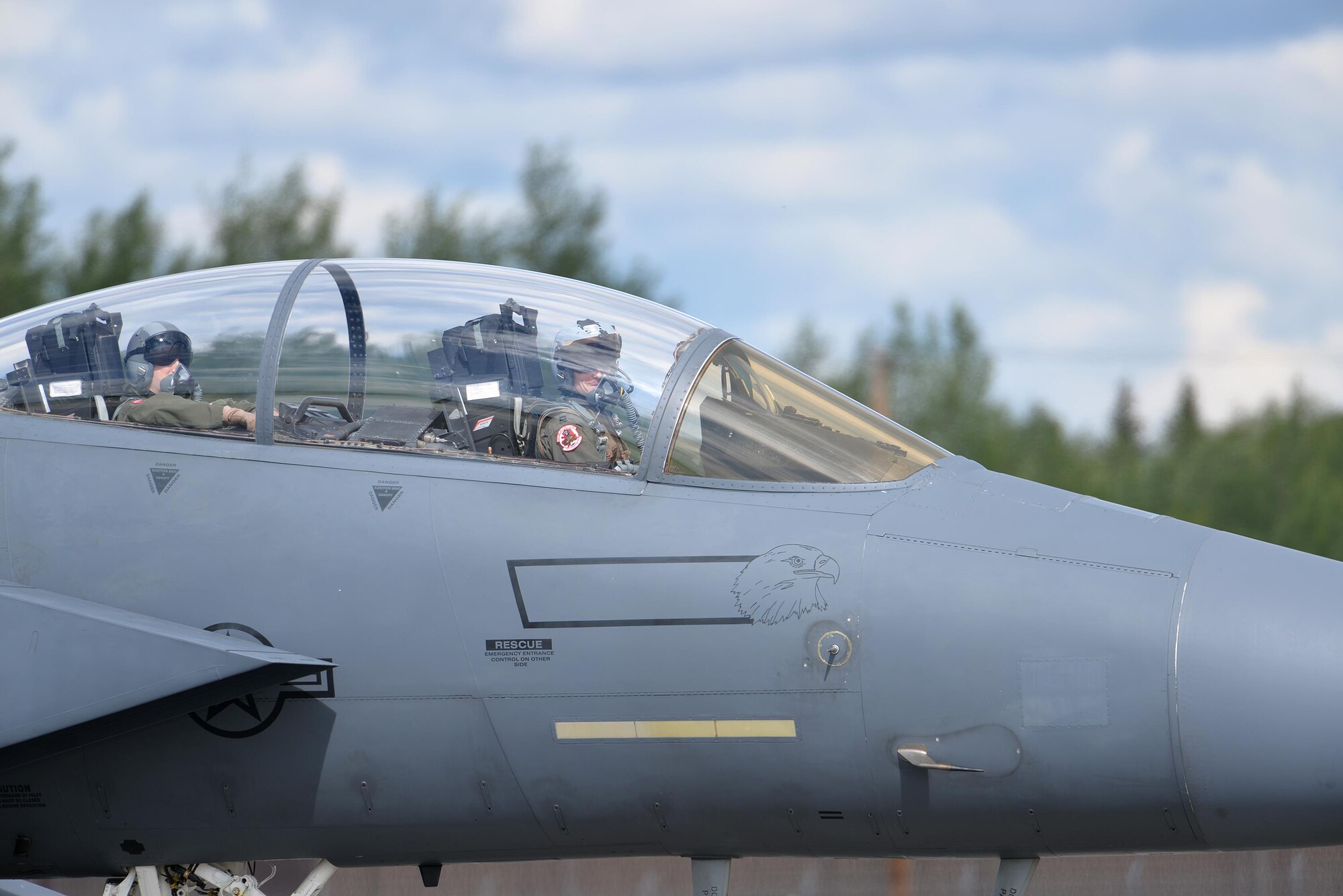 A U.S. Air Force F-15E Strike Eagle pilot and weapon systems officer assigned to the 494th Fighter Squadron out of Royal Air Force Lakenheath, England, look over as they taxi down the Eielson Air Force Base, Alaska, flight line in their all-weather, highly maneuverable, dual-role fighter June 6, 2016, during RED FLAG-Alaska (RF-A) 16-2. RF-A is a series of Pacific Air Forces commander-directed field training exercises that provides unique opportunities to integrate various forces like the Liberty Wing into joint, coalition and multilateral training from simulated forward operating bases. (U.S. Air Force photo by Master Sgt. Karen J. Tomasik/Released)