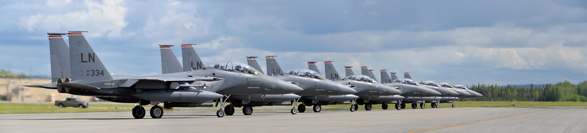 A row of U.S. Air Force F-15E Strike Eagle all-weather, highly maneuverable, dual-role fighter aircraft assigned to the 494th Fighter Squadron out of Royal Air Force Lakenheath, England, wait for their turn to launch for an afternoon sortie out of Eielson Air Force Base, Alaska, June 6, 2016, during RED FLAG-Alaska (RF-A) 16-2. RF-A is a series of Pacific Air Forces commander-directed field training exercises for U.S. and partner nation forces like the Liberty Wing, enabling joint and international units to sharpen their combat skills by flying simulated combat sorties in a realistic threat environment inside the Joint Pacific Alaska Range Complex, the largest instrumented air, ground and electronic combat training range in the world. (U.S. Air Force photo illustration by Master Sgt. Karen J. Tomasik/Released)