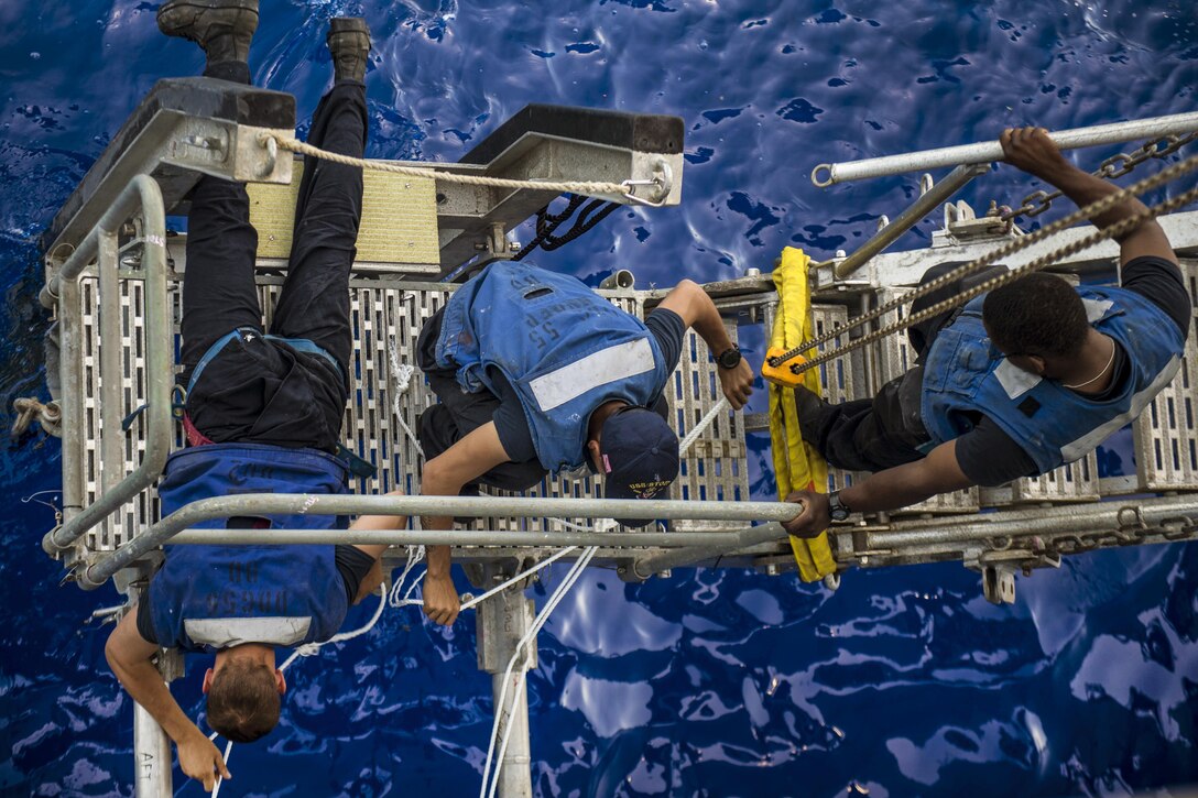 Navy Petty Officer 3rd Class Parker Tait, left, Petty Officer 2nd Class Carlos Vela, center, and Seaman Jarodd Johnson secure an accommodation ladder aboard the USS Stout  while transiting the Mediterranean Sea, June 8, 2016. Tait and Vela are boatswain's mates. The guided-missile destroyer is supporting U.S. national security interests in Europe. Navy photo by Mass Communication Specialist 3rd Class Bill Dodge
