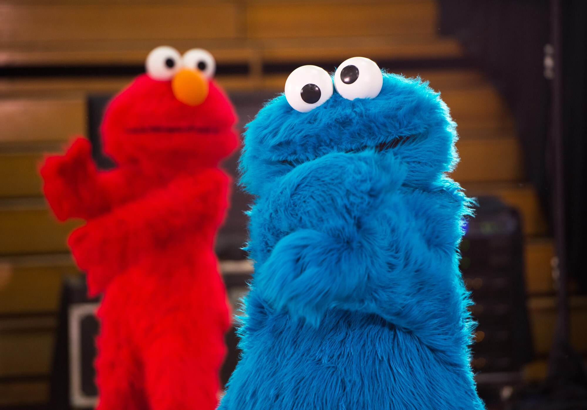 Sesame Street characters Cookie Monster and Elmo perform dance moves during the Sesame Street USO Experience for Military Families show at Travis Air Force Base, Calif., June 6, 2016. The Sesame Street USO Experience for Military Families was a 35-minute show featuring four of the popular Sesame Street costumed characters, as well as Katie, a military child created especially for the USO. Katie appears in two shows, the “moving show” which depicts her leaving friends as she moves to a new base and the “transition show” in which her family is permanently separating from the military. (U.S. Air Force photo by Louis Briscese/Released)   