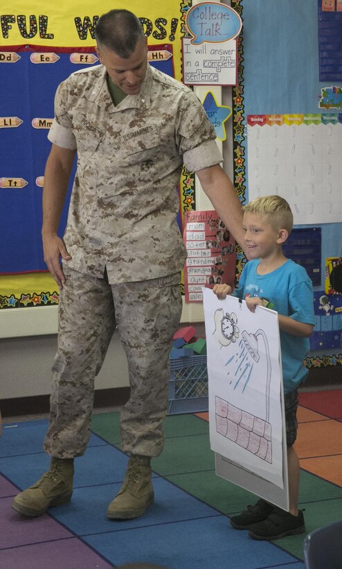 Lt. Col. Timothy Pochop, director, Natural Resource and Environmental Affairs, congratulates Christopher Halles, kindergartener, for being a finalist in the 2016 Earth Day Poster Contest at Condor Elementary School June 6, 2016. (Official Marine Corps photo by Cpl. Thomas Mudd/Released)