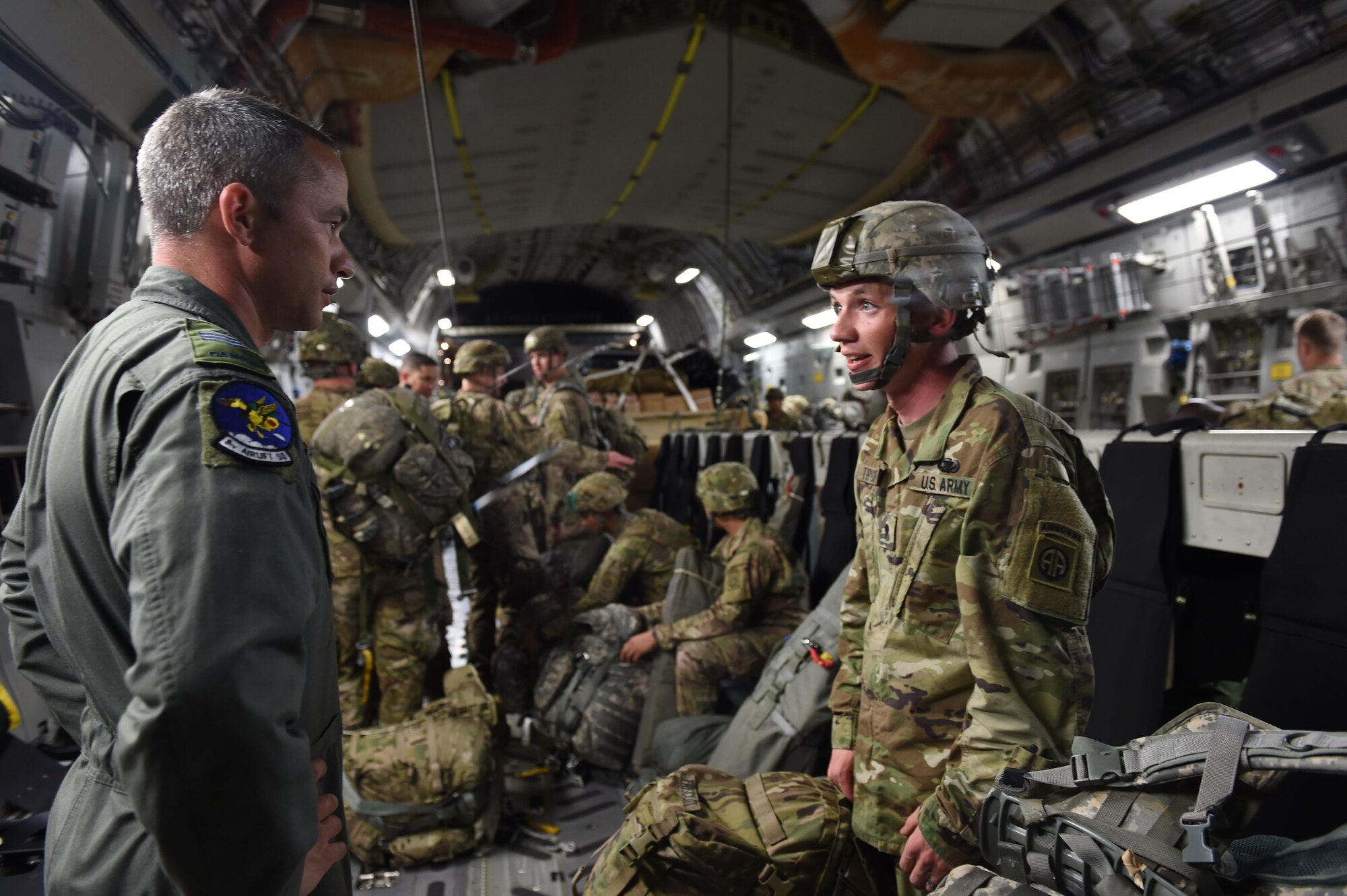 Royal Canadian Air Force Sgt. Wes Ramsay, 8th Airlift Squadron loadmaster, speaks to Army SPC. Dakota Truscott, 82nd Airborne Division, on a 62nd Airlift Wing C-17 Globemaster III at Pope Army Air Field, N.C., on June 6, 2016. Ramsay, who was participating in Exercise Swift Response, is part of an Air Force exchange program at Joint Base Lewis-McChord, Wash., and has worked at McChord for two years. (Air Force photo/Staff Sgt. Naomi Shipley)