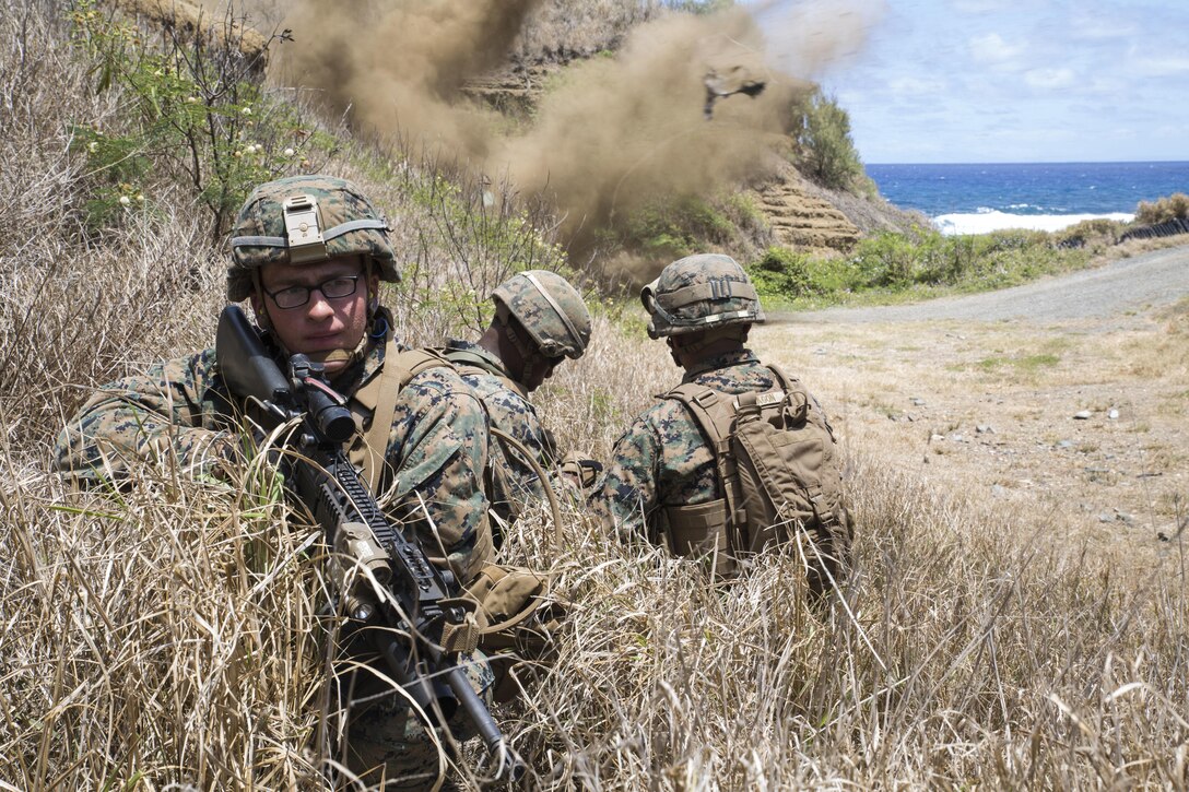Pfc. Andrew Falk, a rifleman with Echo Company, 2nd Battalion, 3rd Marine Regiment, and a Strafford, Mo., native, provides rear security as a M18 claymore mine explodes during a squad ambush part of a squad attack exercise at Kaneohe Bay Range Training Facility aboard Marine Corps Base Hawaii, April 21, 2016. The purpose of this exercise was to help team and squad leaders improve their combat assault capabilities as a cohesive unit with fire support from mortars and machine gun suppression. Echo Marines buddy-rushed targets using live rounds, set up an ambush with a claymore and used rocket fire to suppress armored targets. 