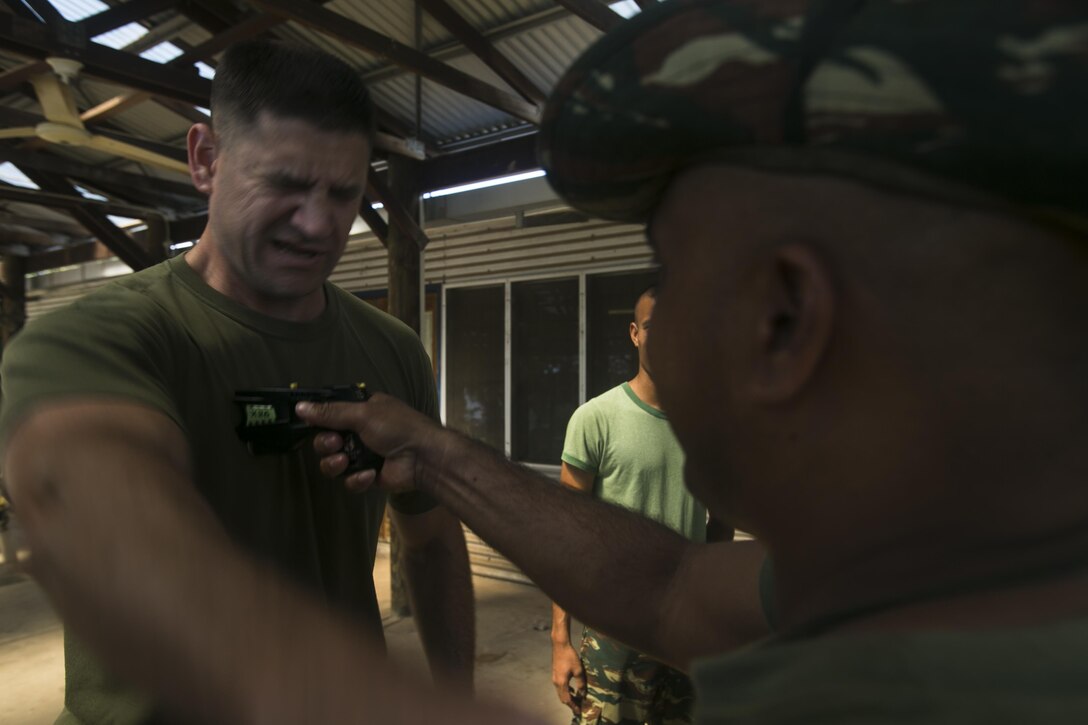 Sgt. Marten L. Malimau (Right) conducts a drive stun on Maj. Todd A. Peterson (Left) during a non-lethal weapons course, June 7, 2016, at Metinaro, Timor Leste, as part of Exercise Crocodilo 16. The non-lethal weapons course gives U.S. Marines the opportunity to instruct Timorese soldiers on less-than-lethal methods to handle future disputes. Malimau is an infantryman with Bravo Company, 1st Battalion, Timor Leste Defense Force. Peterson, from Westland, Michigan, is the commanding officer with Task Force Koa Moana, originally the operations officer with 9th Engineer Support Battalion, 3rd Marine Logistics Group, III Marine Expeditionary Force.