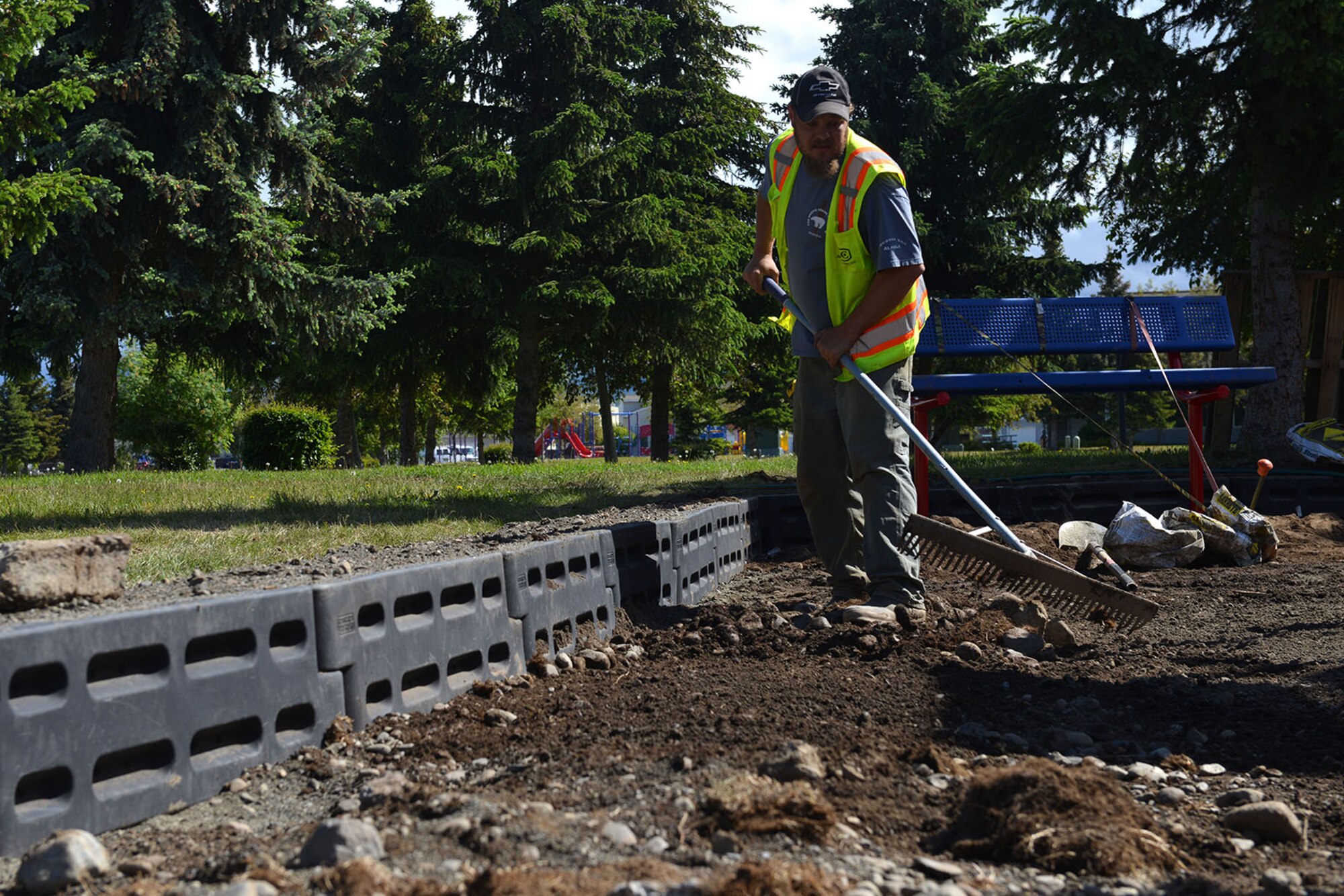 Eric Stone, a playground specialist with Alaska Playground Specialist, levels the earth at the Sunflower Housing Community playground on Joint Base Elmendorf-Richardson, Alaska, June 7, 2016. Renovations to the almost 100-square-foot playground come as a means to improve safety and to meet demand. (U.S. Air Force photo by Airman 1st Class Javier Alvarez)