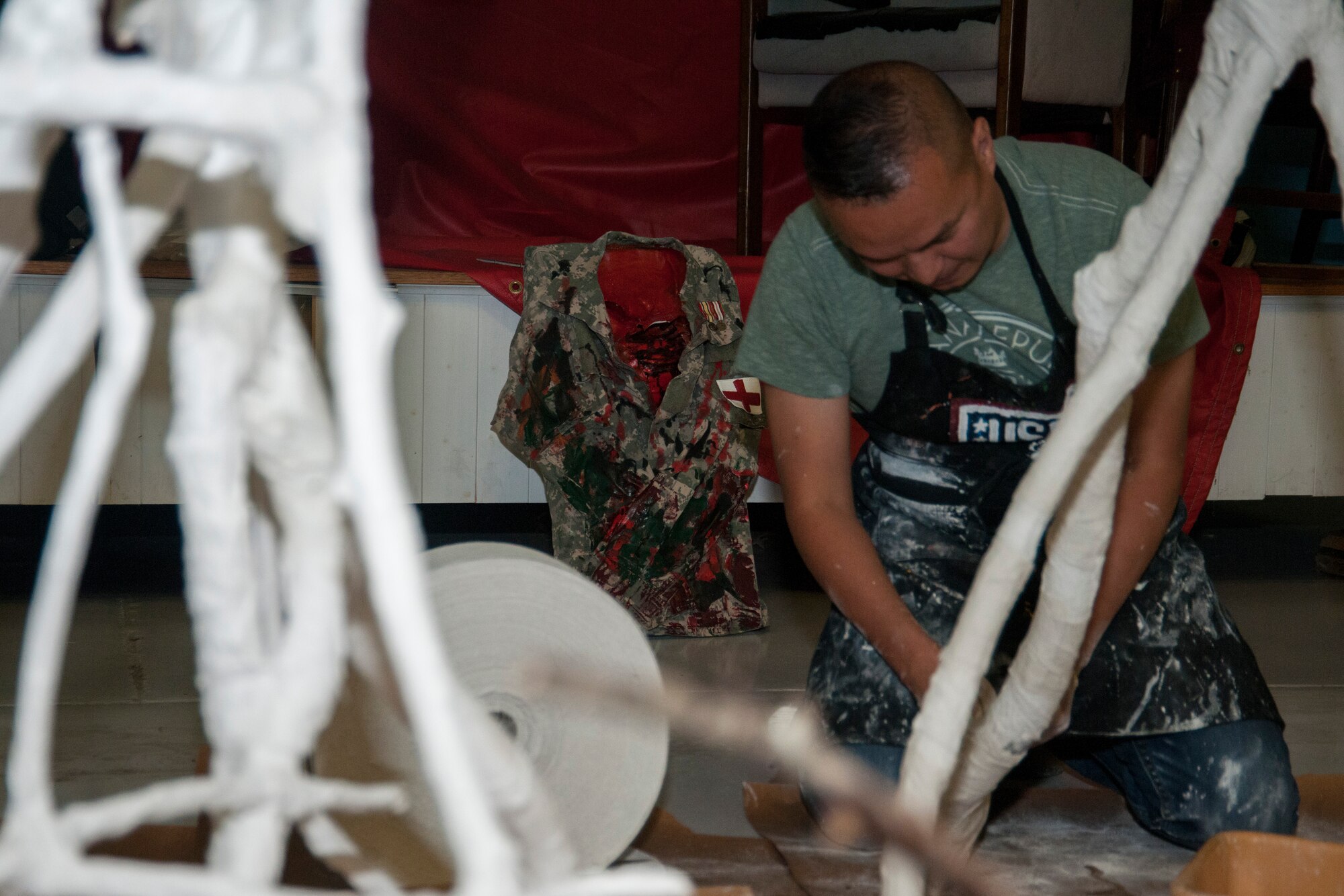 Retired Tech. Sgt. Steven Luu applies casting tape to branches to form a tree in Hangar 4 at Joint Base Andrews, Md., May 25, 2016. Luu came to JBA to put the finishing touches on his tree sculpture, titled: The Day After Combat, as part of an art therapy program. (U.S. Air Force photo by Airman Gabrielle Spalding)