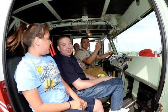 JoshJoshua Jones, along with sisters Rachel, front, and Merriam, back, receives a fire truck tour from Airman 1st Class Franky Martinez, 419th Civil Engineer Squadron, June 9 at Hill Air Force Base, Utah. Jones, who has a life-threatening illness, loves fire trucks and firefighters and got to become a firefighter for a day. While here, he and is family toured a fire station, rode in a fire truck, and participated in firefighting drills with reservists from the 419th Fighter Wing. (U.S. Air Force photo by Todd Cromar) 