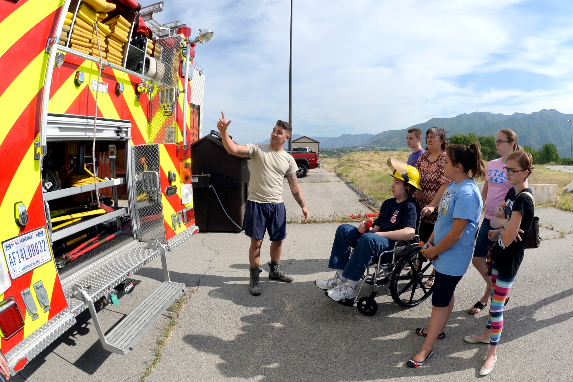 Staff Sgt. Anthony Runco, a reservist in the 419th Civil Engineer Squadron, talks about firefighting equipment with Joshua Jones and his family June 9 at Hill Air Force Base, Utah. Jones, who is enduring a life-threatening illness, became a firefighter for a day. While here, he and is family toured a fire station, rode in a fire truck, and participated in firefighting drills. (U.S. Air Force photo by Todd Cromar) 