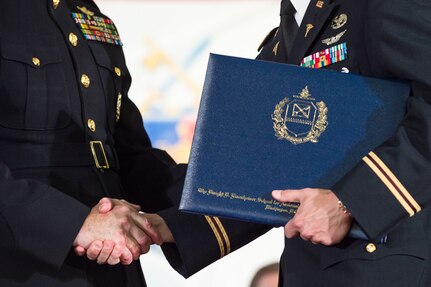 Marine Corps Gen. Joe Dunford, chairman of the Joint Chiefs of Staff, congratulates a graduate during the National Defense University's 2016 graduation ceremony at Fort Lesley J. McNair in Washington, D.C., June 9, 2016. The university provides military education to senior leaders. DoD photo by Army Staff Sgt. Sean K. Harp