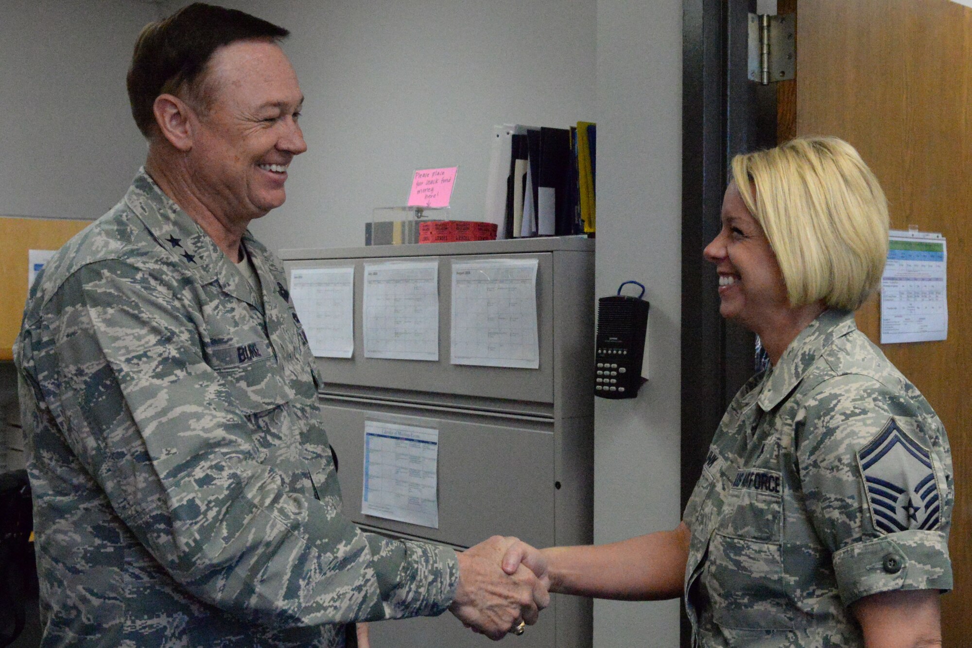 Air Force District of Washington Commander Maj. Gen. Darryl Burke presents a coin to Senior Master Sgt. Jennifer Klink in the dental clinic on Joint Base Anacostia-Bolling, Washington D.C., June 9, 2016. Klink was recognized by Gen. Burke for her efforts in making 2015 AFDW Annual Awards banquet a memorable event.