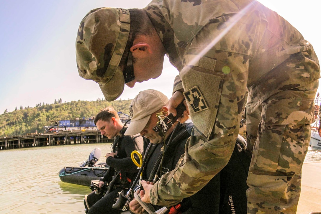 Army Staff Sgt. Matthew Tammaso inspects equipment during the Joint Logistics Over the Shore training dive at the Port of Tacoma, Wash., June 8, 2016. Tammaso is the diving supervisor assigned to 569th Engineer Dive Detachment. The divers inspected the piers for structural damage. Army photo by Spc. Adeline Witherspoon