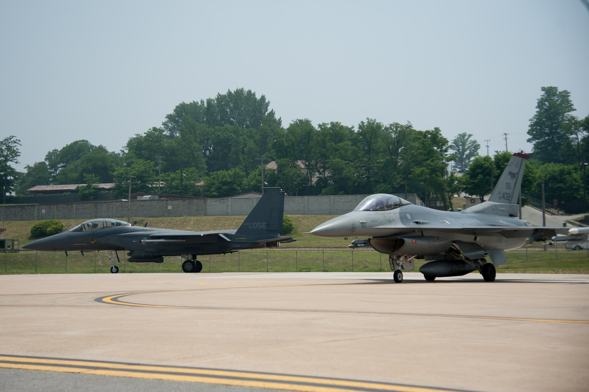 A Republic of Korea air force F-15K Slam Eagle from the 11th Fighter Wing and a U.S. Air Force F-16 Fighting Falcon from the 36th Fighter Squadron line up to take off from Osan Air Base, ROK, June 9, 2016. F-16s and F-15s worked together during Buddy Wing 16-5, which allowed pilots to focus on the fundamentals of air-to-air combat training. (U.S. Air Force photo by Staff Sgt. Jonathan Steffen/Released)