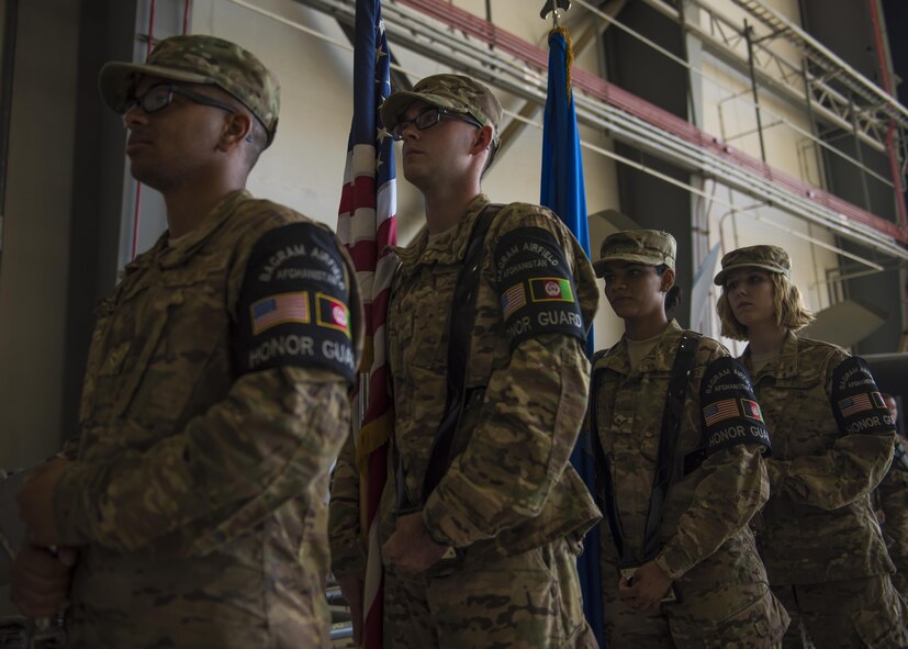 Airman 1st Class Christian Higgins (left), Senior Airman John Roach, Airman 1st Class Bijal Patel, and Staff Sgt. Megan Montagnino, 455th Air Expeditionary Wing Honor Guard, stand at parade rest before posting the colors during the 455th AEW change of command ceremony at Bagram Airfield, Afghanistan, June 03, 2016. The honor guard participated in a demonstration that showcased their training, fitness, teamwork, precision and military bearing. (U.S. Air Force photo by Senior Airman Justyn M. Freeman)