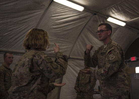 Senior Airman John Roach and Staff Sgt. Megan Montagnino, 455th Air Expeditionary Wing Honor Guard, play rock, paper, scissors for a spot in an upcoming ceremony at Bagram Airfield, Afghanistan, June 08, 2016. Members of the 455th AEW Honor Guard consist of volunteers from different base units. (U.S. Air Force photo by Senior Airman Justyn M. Freeman)