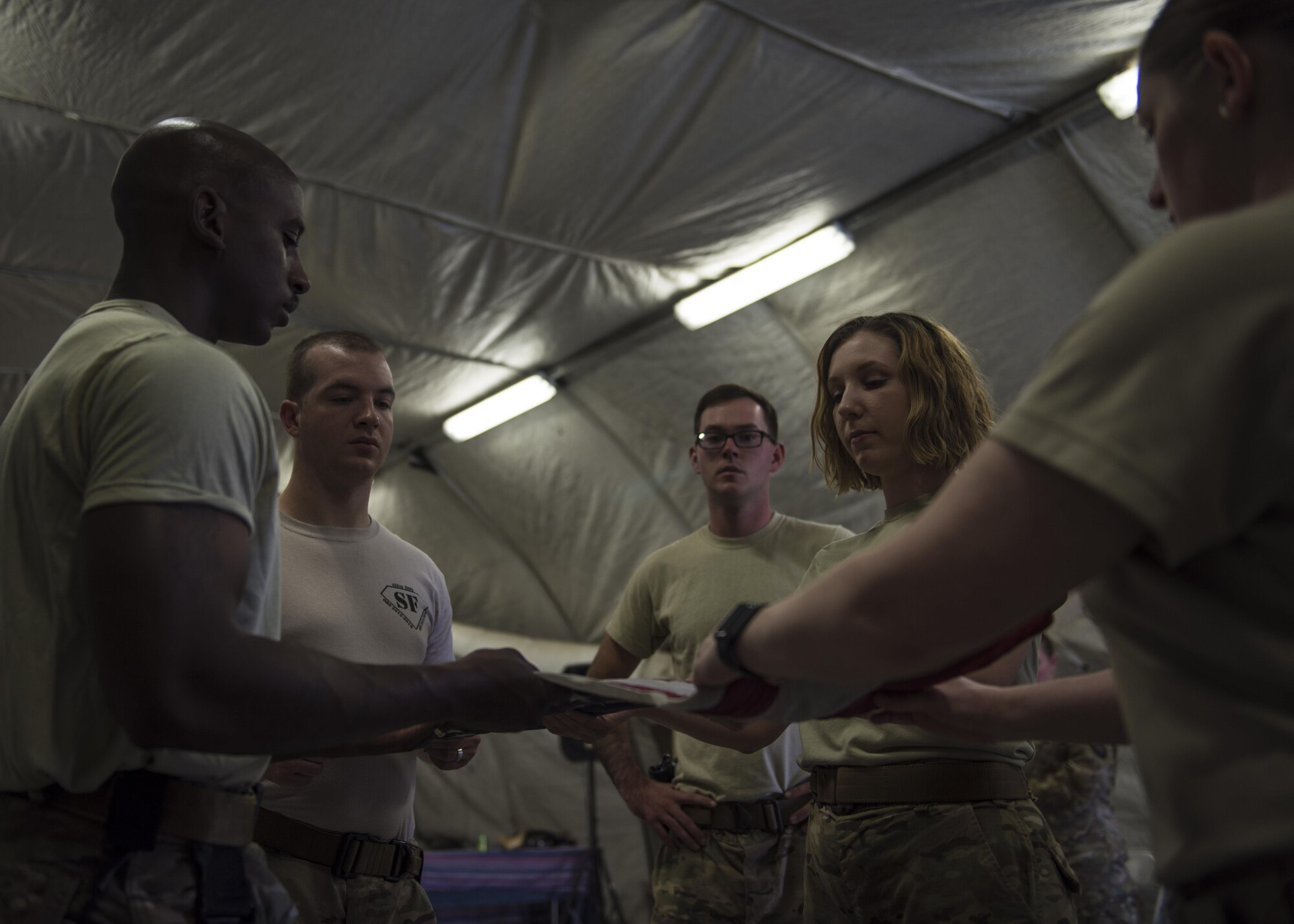 Airman from the 455th Air Expeditionary Wing Honor Guard practice folding the flag at Bagram Airfield, Afghanistan, June 08, 2016. The flag is carefully folded into the shape of the tri-cornered hat, reminiscent of the hats worn by the soldiers who fought and won the revolution for American independence. (U.S. Air Force photo by Senior Airman Justyn M. Freeman)