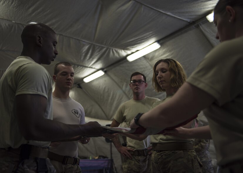 Airman from the 455th Air Expeditionary Wing Honor Guard practice folding the flag at Bagram Airfield, Afghanistan, June 08, 2016. The flag is carefully folded into the shape of the tri-cornered hat, reminiscent of the hats worn by the soldiers who fought and won the revolution for American independence. (U.S. Air Force photo by Senior Airman Justyn M. Freeman)