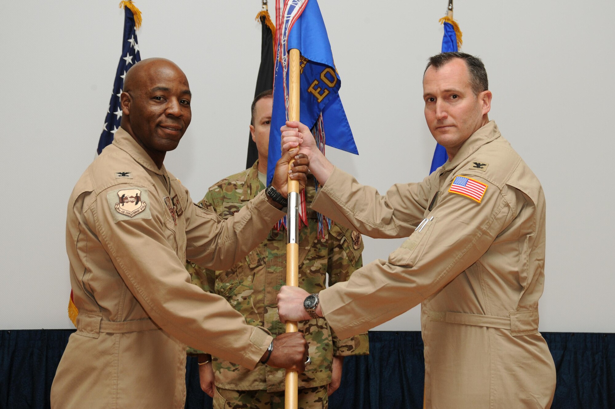 Col. Charles Stevens assumes command of the 386th Expeditionary Operations Group and receives the guidon from Col. Clarence Lukes Jr., 386th Air Expeditionary Wing commander, during an assumption of command ceremony at an undisclosed location in Southwest Asia, June 8, 2016. Prior to assuming command of the 386 EOG, Stevens served as the deputy division chief, Joint Operations Division-AFRICOM, Operations Directorate, J-3 Joint Staff at the Pentagon in Washington D.C. Stevens will lead a team of Soldiers, Sailors, and Airmen providing tactical airlift, aeromedical evacuation, search and rescue, personnel recovery, intelligence, surveillance, reconnaissance, and operational support capabilities throughout Southwest Asia. (U.S. Air Force photo by Senior Airman Zachary Kee)