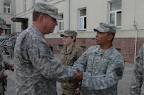 Chief Warrant Officer 2 Noel F. Gaoiran, with the 364th Expeditionary Sustainment Command, is presented with a commander's coin from Command Sgt. Maj. Thomas P. Brashears, the command sergeant major with the 364th ESC, for his exceptional contribution to Anakonda 2016 in Warsaw, Poland, June 6, 2016. Anakonda 2016 is one of U.S. Army Europe's premier multinational training events, which features 24 nations and seeks to train, exercise and integrate Polish national command and force structures into an allied, joint, multinational environment.