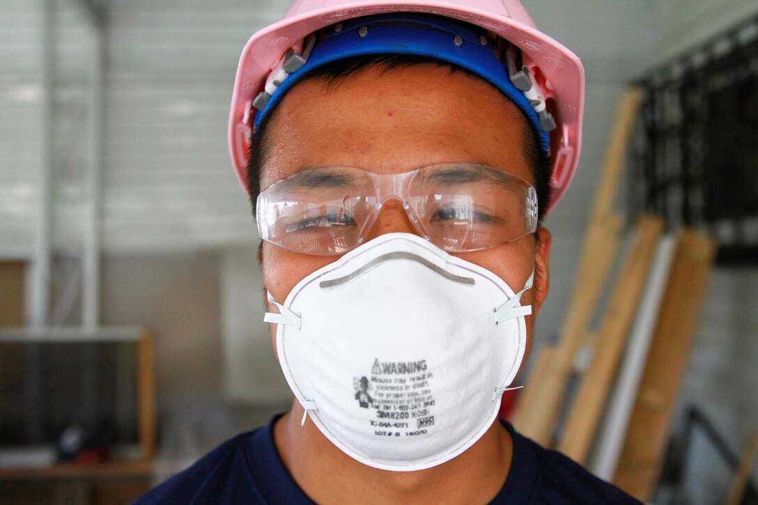 Kevin Wu, a poolees with Recruiting Station New York, is seen wearing a hardhat and face mask while volunteering with Habitat for Humanity, a non-profit organization that builds and fixes homes for the less fortunate, in repairing a two-story home on Coney Island in Brooklyn, N.Y., on 28 May, 2016, that was damaged during Hurricane Sandy in 2013. (U.S. Marine Corps photo by Cpl. Brand on Thomas)