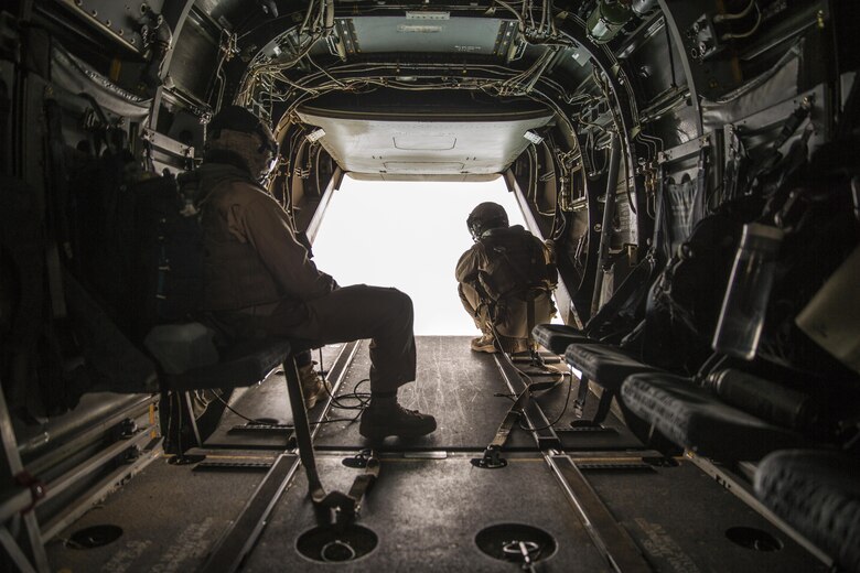 Two crew chiefs with Marine Medium Tiltrotor Squadron (VMM) 165 observe the area outside an MV-22B Osprey during a flight from Marine Corps Air Station Miramar to Marine Corps Base Camp Pendleton, Calif., June 8. Crew chiefs worked alongside Osprey pilots in order to maintain visuals for the overall flight. (U.S. Marine Corps photo by Sgt. Michael Thorn/Released)