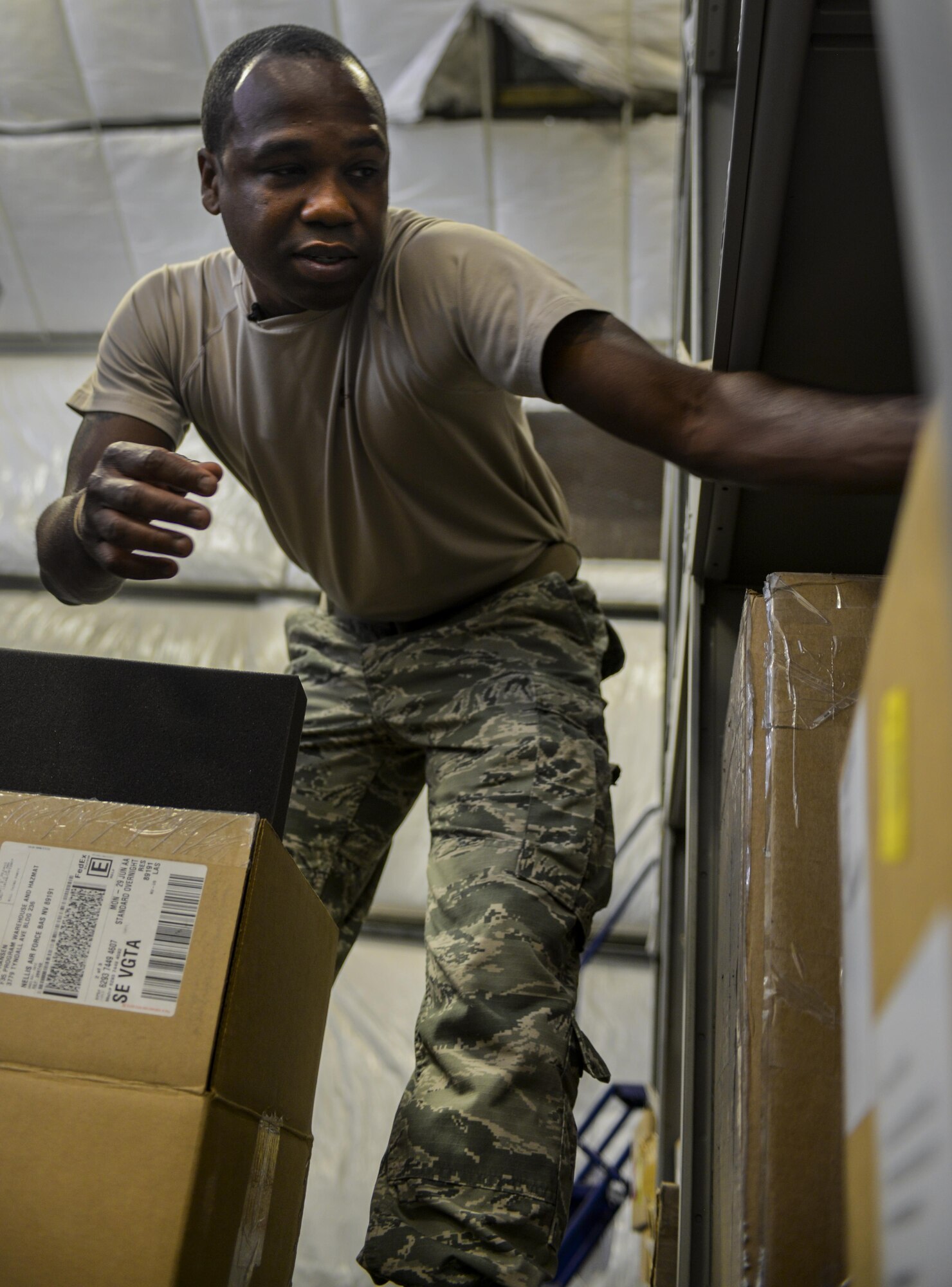 Staff Sgt. Wendell Belford, 99th Logistics Readiness
Squadron F-35 Aircraft Parts Store supervisor, reaches for
a box while preparing to move parts from the old to the
new location, at Nellis Air Force Base, Nev., June 6. The
amenities that the new facility provides will allow the
Airmen of the F-35 parts shop to accomplish their missions,
and with the growth of the F-35 program increasing in size
the 99th LRS had to follow suit. (U.S. Air Force photo by Airman 1st Class Kevin Tanenbaum)