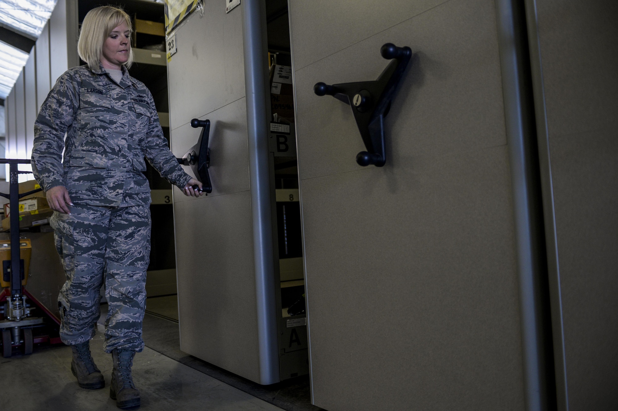 Tech. Sgt. Tiffany Larson, 99th Logistics Readiness Squadron NCO in-charge of F-35 Aircraft Parts Store, closes one shelving unit as the from the F-35 Aircraft Parts Store move parts to their new location at Nellis Air Force Base, Nev., June 6. The pairing of the parts store and Lockheed Martin runs deeper than only an in-house service representative, with the process of receiving and distributing orders also being interwoven between the two. (U.S. Air Force photo by Airman 1st Class Kevin Tanenbaum)