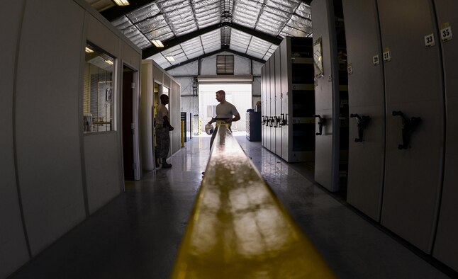 Senior Airman Adam Johnson, 99th LRS F-35 Aircraft Parts Store journeyman, and Staff Sgt. Wendell Belford, 99th LRS F-35 Aircraft Parts Store supervisor, move aircraft parts to their new location at Nellis Air Force Base, Nev., June 6. All of these changes being made to not only the location of the F-35 Aircraft Parts Store, but also what is taught to airmen at the schoolhouse, will make it that much easier for the shop to accomplish their pivotal mission. (U.S. Air Force photo by Airman 1st Class Kevin Tanenbaum)