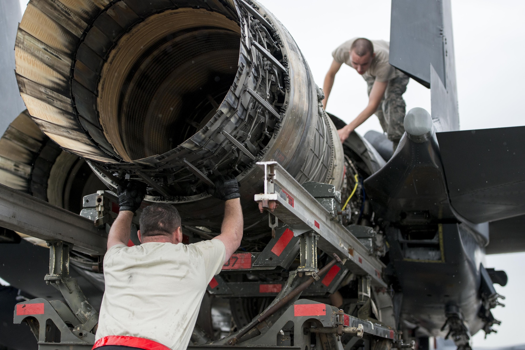 U.S. Air Force Tech. Sgt. Kevin Brown and Airman 1st Class Collin Blackburn, both aerospace propulsion technicians assigned to the 494th Aircraft Maintenance Unit out of Royal Air Force Lakenheath, England, guide an engine into place on an F-15E Strike Eagle dual-role fighter aircraft June 8, 2016, during RED FLAG-Alaska (RF-A) 16-2 at Eielson Air Force Base, Alaska. During RF-A, maintenance units work diligently to keep jets operational despite a high-operations tempo created by the simulated deployed environment, preparing U.S. and partner-nation forces for contingency operations. (U.S. Air Force photo by Capt. Elias Zani/Released)