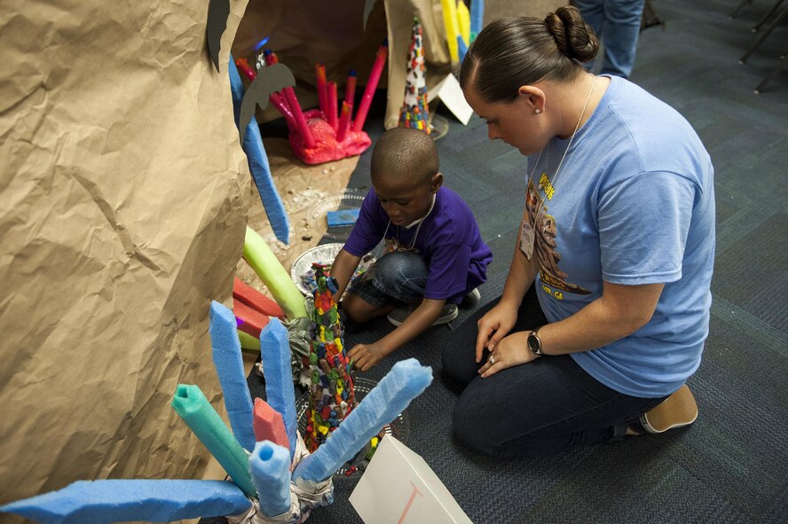 Eli Wallace, son of U.S. Air Force Master Sgt. Marvin Wallace, 23d Maintenance Group, participates in an activity with the help of volunteer 2nd Lt. Crystal Hensley, 23d Wing deputy chief of protocol, during Vacation Bible School, June 7, 2016, at Moody Air Force Base, Ga. Children participated in activities such as skits, song and dance, games, interactive Bible stories and watched movies during VBS. (U.S. Air Force photo by Airman 1st Class Lauren M. Hunter/Released)