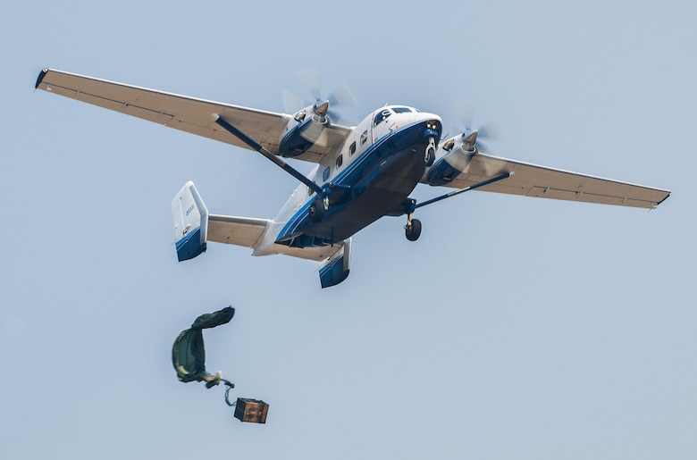 A parachuted bundle soars out of the back of a C-145 Skytruck during an airdrop mission over the Eglin Air Force Base range.  New and prior-qualified loadmasters release sandbags and 300-pound boxes from the 919th Special Operations Wing aircraft to as part of their initial airdrop or proficiency training.  The 919th Special Operations Logistics Readiness Squadron’s Airmen are responsible for packing, securing and recovering the equipment and parachutes.  (U.S. Air Force photo/Tech. Sgt. Sam King)  