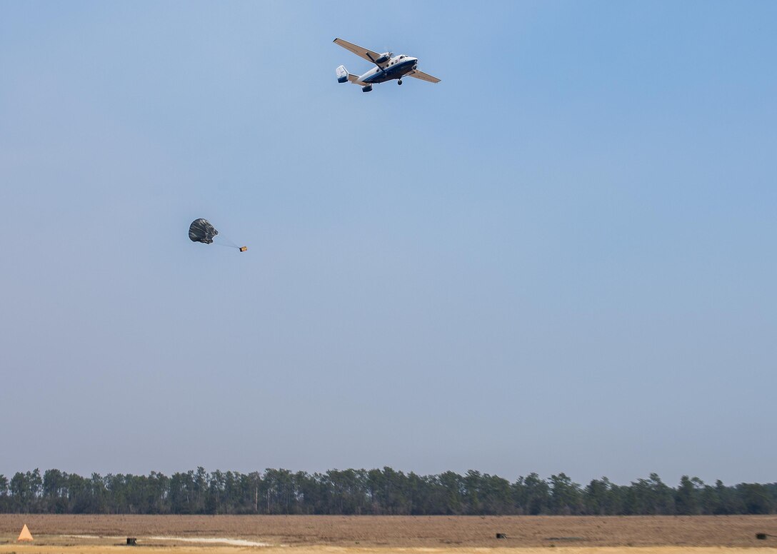 A parachuted bundle soars out of the back of a C-145 Skytruck during an airdrop mission over the Eglin Air Force Base range.  New and prior-qualified loadmasters release sandbags and 300-pound boxes from the 919th Special Operations Wing aircraft to as part of their initial airdrop or proficiency training.  The 919th Special Operations Logistics Readiness Squadron’s Airmen are responsible for packing, securing and recovering the equipment and parachutes.  (U.S. Air Force photo/Tech. Sgt. Sam King)  