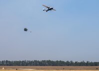 A parachuted bundle soars out of the back of a C-145 Skytruck during an airdrop mission over the Eglin Air Force Base range.  New and prior-qualified loadmasters release sandbags and 300-pound boxes from the 919th Special Operations Wing aircraft to as part of their initial airdrop or proficiency training.  The 919th Special Operations Logistics Readiness Squadron’s Airmen are responsible for packing, securing and recovering the equipment and parachutes.  (U.S. Air Force photo/Tech. Sgt. Sam King)  
