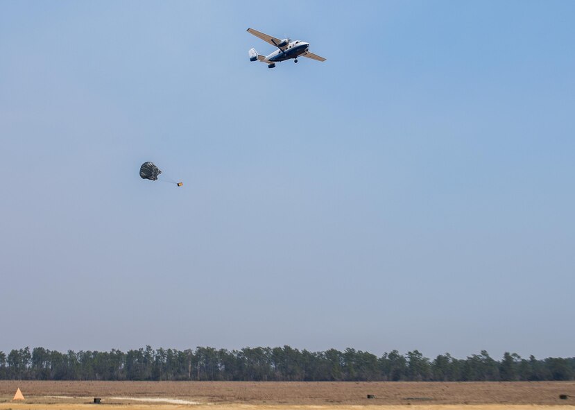 A parachuted bundle soars out of the back of a C-145 Skytruck during an airdrop mission over the Eglin Air Force Base range.  New and prior-qualified loadmasters release sandbags and 300-pound boxes from the 919th Special Operations Wing aircraft to as part of their initial airdrop or proficiency training.  The 919th Special Operations Logistics Readiness Squadron’s Airmen are responsible for packing, securing and recovering the equipment and parachutes.  (U.S. Air Force photo/Tech. Sgt. Sam King)  