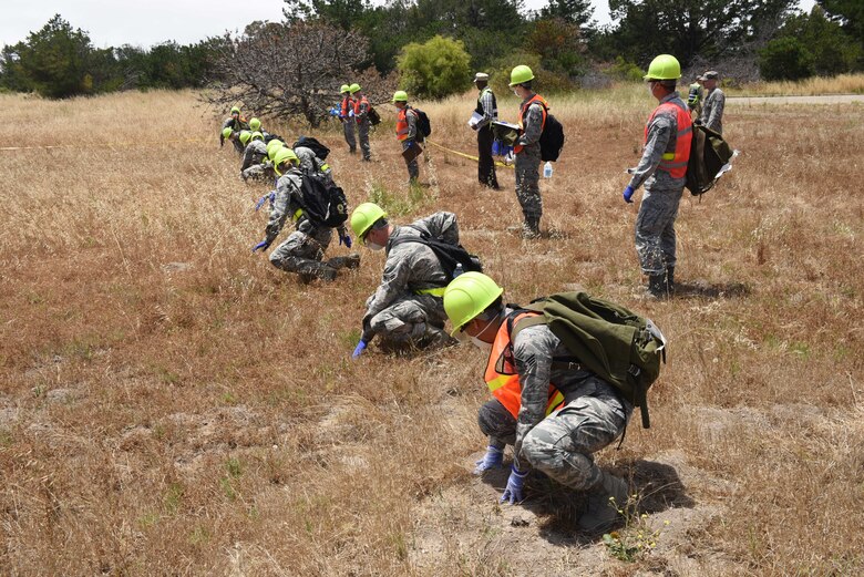 A Search and Recovery team examine a simulated aircraft crash site, June 7, 2016, Vandenberg Air Force Base, Calif. In an effort to measure proficiencies and deficiencies, Airmen throughout Vandenberg recently participated in a base-wide emergency management evaluation.