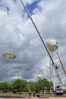 Construction crew members watch as the top of the former water tower descends at Duke Field, Fla. During demolition work, crews found a nameplate attached that indicated the 70,000-gallon water tank was originally erected in 1942, predating the passing of the base's namesake, 1st Lt. Robert L. Duke, who was killed the following year.  (U.S. Air Force photo/Dan Neely)  