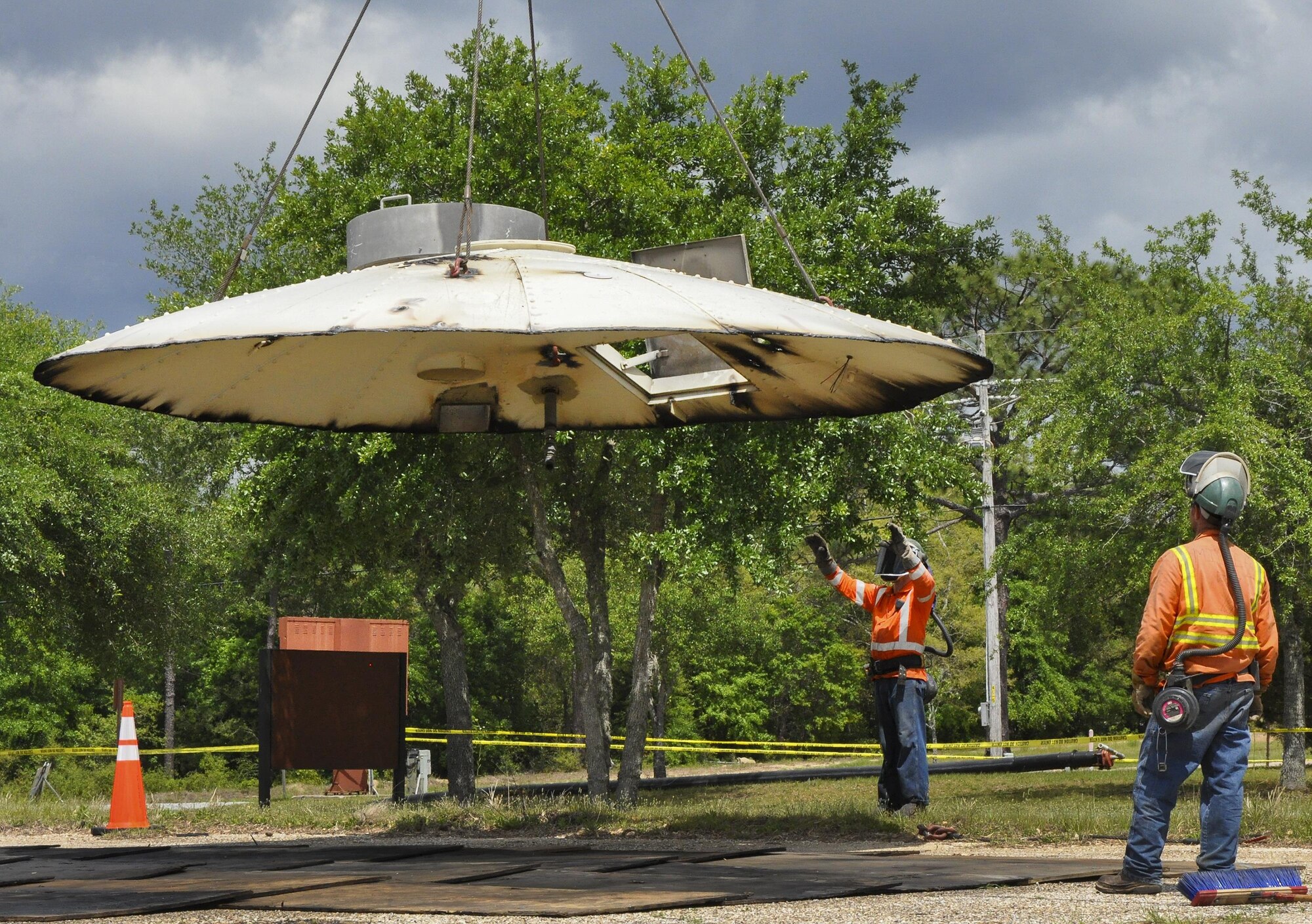 Construction crew members watch as the top of the former  water tower is lowered down at Duke Field, Fla. During demolition work, crews found a nameplate attached that indicated the 70,000-gallon water tank was originally erected in 1942, predating the passing of the base's namesake, 1st Lt. Robert L. Duke, who was killed the following year.  (U.S. Air Force photo/Dan Neely)  